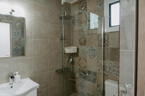 y baño con ducha, aseo y lavamanos. en Oikies Verde III-F, en Perdika