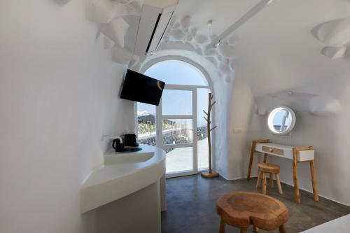 a room with a bed and a table with a mirror at Theano Cave Suites & Villas in Imerovigli