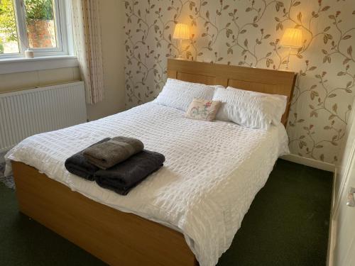 a bedroom with a bed with two towels on it at Laburnum Cottage in Stirling