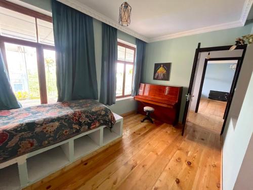 una camera con un letto, uno specchio e un pianoforte di Mishas Haus a Sighnaghi