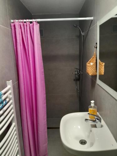 a bathroom with a sink and a pink shower curtain at Apartmani BET Gradačac 1 Maj broj 24 in Gradačac