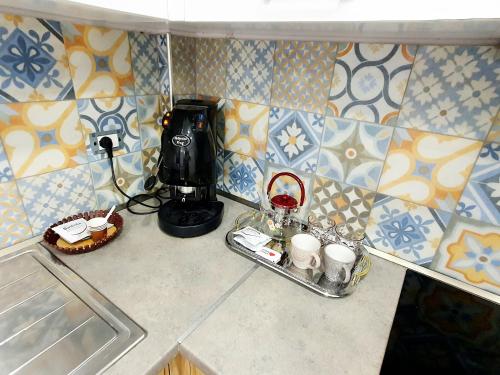 a kitchen counter with a coffee maker and cups at Apartament me qera Dublex Lungomare in Vlorë