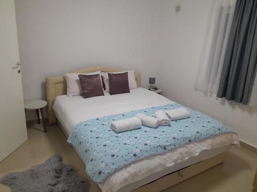 a bedroom with a bed with two towels on it at Apartmani BET Gradačac 1 Maj broj 24 in Gradačac
