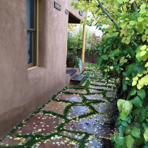 a garden with a stone walkway next to a building at Antigua Inn in Santa Fe