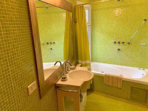 W łazience znajduje się umywalka, wanna i lustro. w obiekcie La Casa del Lago Nahuel w mieście Bariloche
