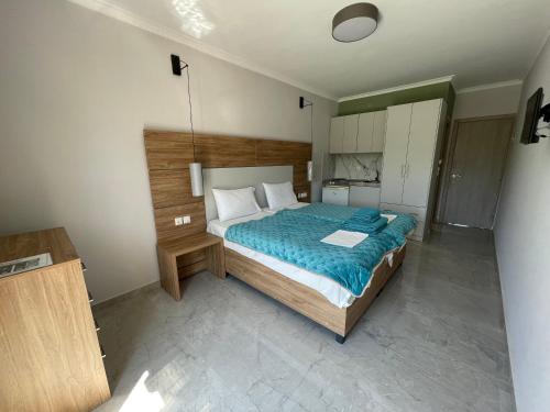 a bedroom with a large bed with a blue blanket at Stella Apartments in Petra