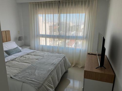 1 dormitorio con 1 cama, TV y ventana en 2 ampios ambientes Av Cordoba-Palermo-Exelente ubicacion en Buenos Aires