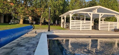 a gazebo next to a pool of water at Garden Panzió in Balatonkeresztúr