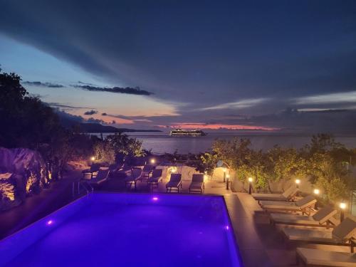 a swimming pool at night with a view of the water at Vila Bello in Ksamil