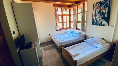 2 camas individuales en una habitación con ventana en Garden Panzió, en Balatonkeresztúr