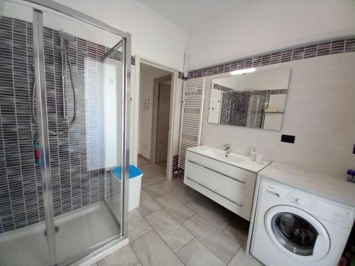 uma casa de banho com um lavatório e uma máquina de lavar roupa em La Rosa BLUtique Guesthouse - Boutique apartment near Como em Lucino