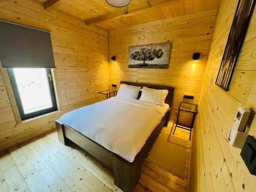 a bedroom with a bed in a wooden cabin at Holiday House Novus in Selno