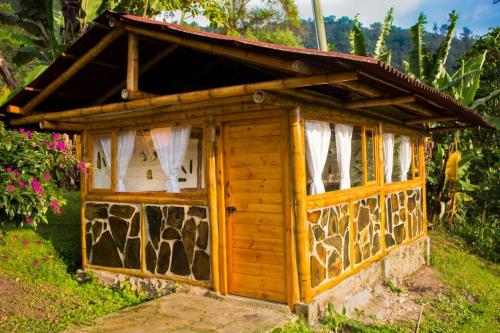 a small wooden dog house in a garden at Cabaña Mikhuna, Bienestar en las montañas !!! in Anolaima