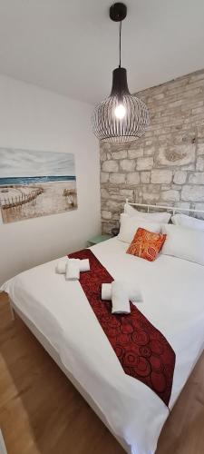 斯普利特的住宿－Augustea Terrace，卧室配有一张大白色床和红色毯子