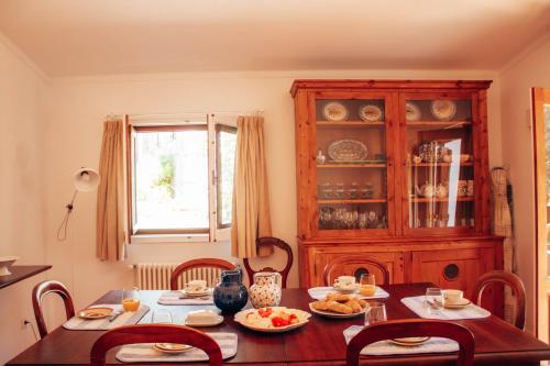 un comedor con una mesa de madera con comida. en Just Like Home Casa do Castanheiro, en Afife