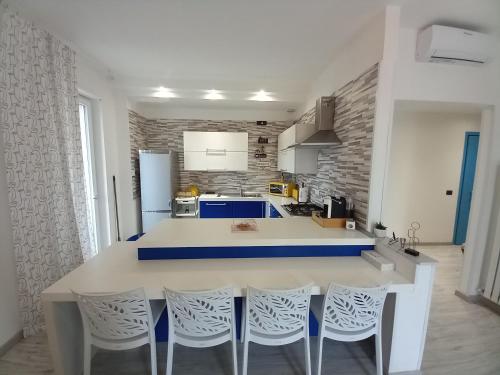 uma cozinha com um balcão e cadeiras brancos e azuis em La Rosa BLUtique Guesthouse - Boutique apartment near Como em Lucino