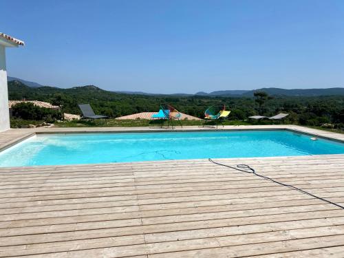 ein großer blauer Pool auf dem Dach eines Hauses in der Unterkunft Mini villa en résidence vue panoramique in Sotta