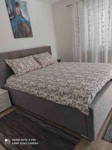 a bedroom with a bed with a flower bedspread at Apartman David in Senj