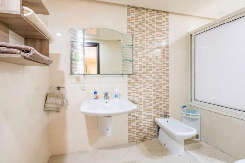 a bathroom with a sink and a toilet and a mirror at Appartement Rabat Agdal City Centre in Rabat