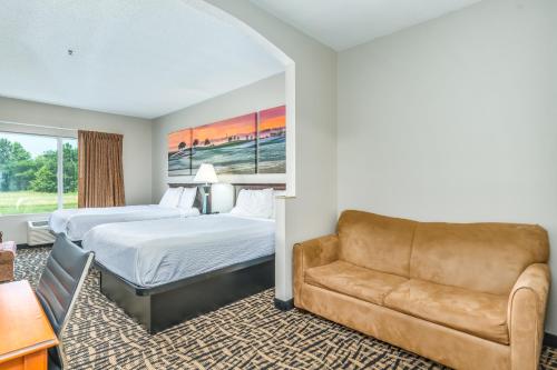 a hotel room with a bed and a couch at Days Inn by Wyndham Coliseum Montgomery AL in Montgomery