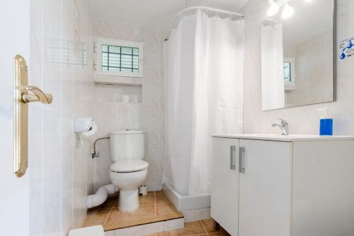 a white bathroom with a toilet and a sink at Apartamentos Mayans in San Ferrán de ses Roques