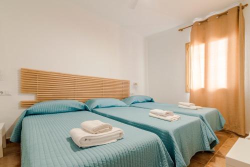 2 Betten mit Handtüchern darüber in einem Schlafzimmer in der Unterkunft Apartamentos Mayans in Sant Ferran de Ses Roques