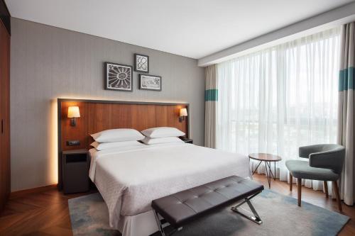 a bedroom with a large bed and a chair at Four Points by Sheraton Istanbul Kagithane in Istanbul