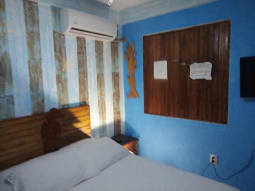 a bedroom with a bed and a blue wall at AH KIN Cancun Centro in Cancún