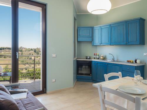 a kitchen with blue cabinets and a table with a view at La Volpe e la Stella by Podere Carriero in Montescaglioso
