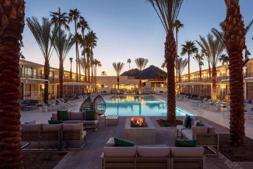 a resort with a pool with palm trees and couches at Hotel Adeline, Scottsdale, a Tribute Portfolio Hotel in Scottsdale
