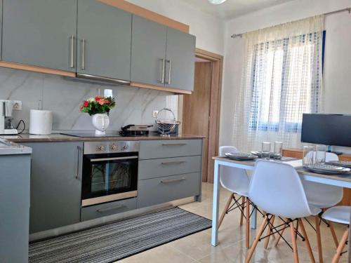 LivadiaにあるDionysia apartmentsのキッチン(テーブル、テーブル、椅子付)