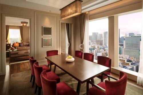 a dining room with a table and red chairs at St. Regis Osaka in Osaka