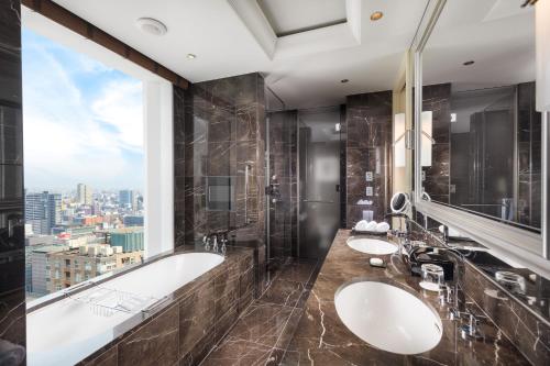 a bathroom with two sinks and a tub and a window at St. Regis Osaka in Osaka