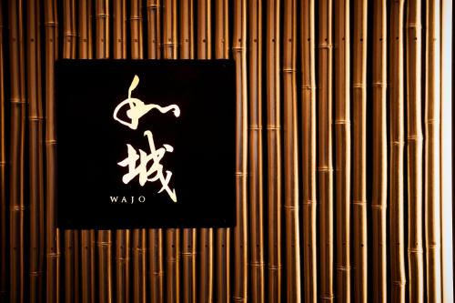 a sign on a bamboo wall with a sign for wahoo at The St. Regis Osaka in Osaka
