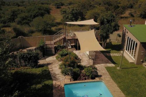 einen Blick über den Pool und ein Zelt in der Unterkunft Comfortable 10 guest villa in a Big 5 Game Reserve in Dinokeng Game Reserve