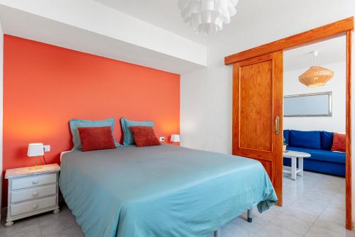 プエルト・デ・サンティアゴにあるPanomaric Sea View - Sol Apartmentのベッドルーム(青いベッド1台、青いソファ付)