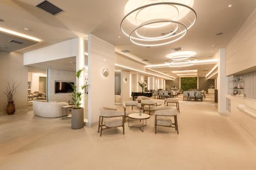 un hall avec des chaises et des tables dans un bâtiment dans l'établissement Holiday Inn Thessaloniki, an IHG Hotel, à Thessalonique