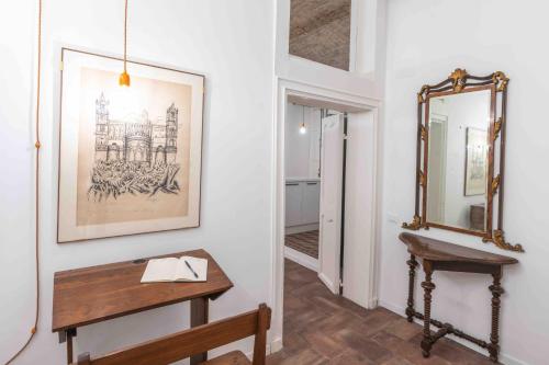 a hallway with a wooden table and a mirror at Calderai 82 suites 1 e 2 in Palermo