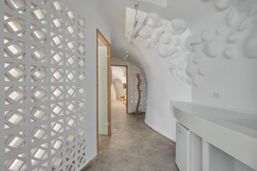 a hallway with a white wall with a geometric pattern at Theano Cave Suites & Villas in Imerovigli