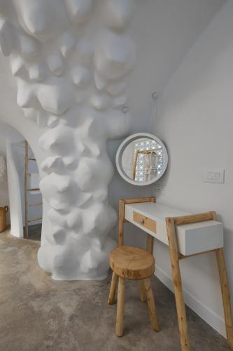 a room with a desk and a mirror and a stool at Theano Cave Suites & Villas in Imerovigli