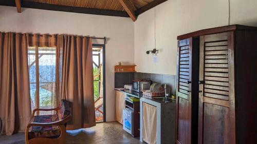 a kitchen with a counter and a microwave in it at Hôtel chez Pat in Nosy Be