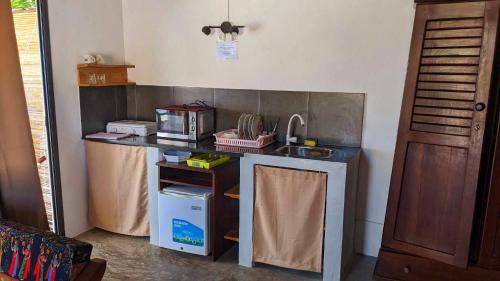 a kitchen with a sink and a counter top at Hôtel chez Pat in Nosy Be