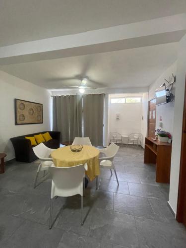 een woonkamer met een tafel en stoelen en een bank bij Centrico Departamento (301) in Cancun
