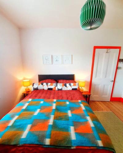 a bedroom with a large bed with a colorful blanket at Casa Colour Margate in Margate