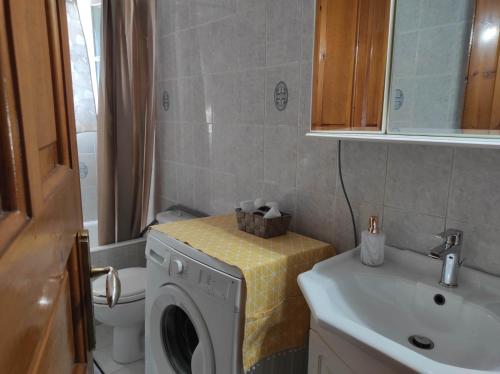 a bathroom with a washing machine and a sink at Angelic House in Spetses