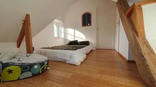a bedroom with a bed and a suitcase on the floor at appartement du croissant in Bayeux