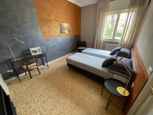 een slaapkamer met een bed en een tafel en stoelen bij Casa indipendente, 250 m dalla spiaggia in Pisa