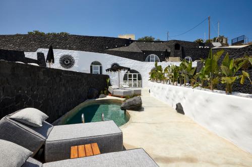 a swimming pool in the backyard of a house at Theano Cave Suites & Villas in Imerovigli