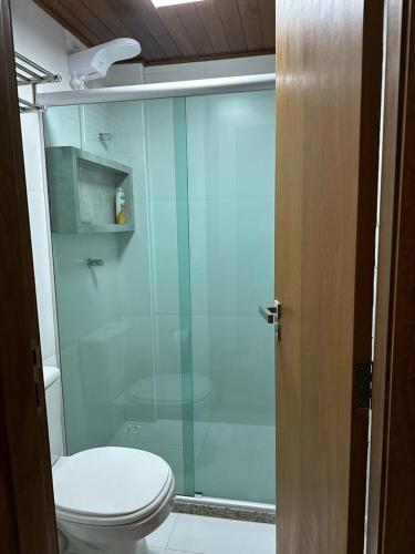 a bathroom with a toilet and a glass shower at Villa Andorinha, Apt 03 in Mucugê