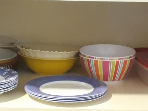 a group of bowls and plates sitting on a shelf at A Pasos de la Playa in Papudo